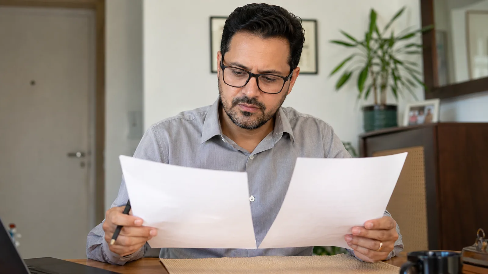 Trabalhador brasileiro analisando holerite e extrato para identificar atraso de FGTS